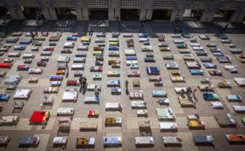 Members of Kibbutz Nir Oz in Jerusalem set up 239 empty beds, symbolizing Israeli hostages