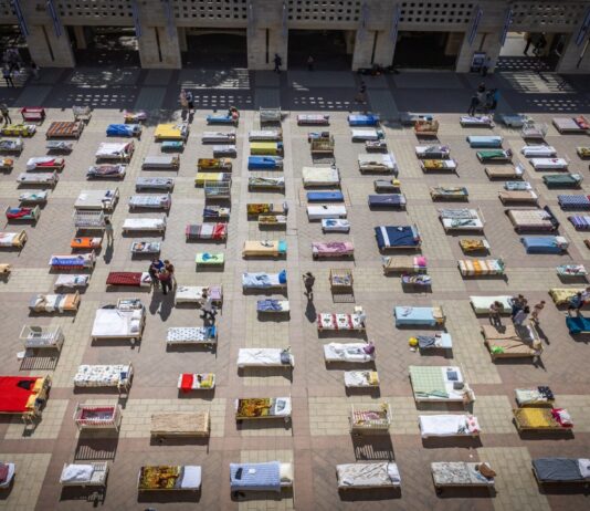 Members of Kibbutz Nir Oz in Jerusalem set up 239 empty beds, symbolizing Israeli hostages